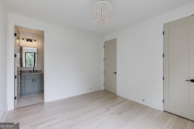 1954 8th St, Chamblee, GA 30341 - unfurnished bedroom with light wood finished floors, a chandelier, a sink, and ensuite bathroom