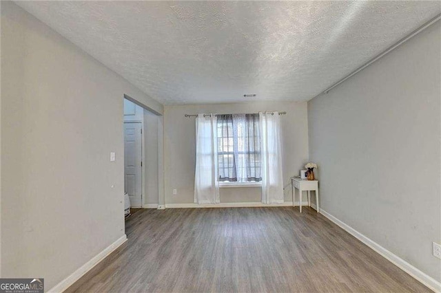1171 Pine Acre Dr, Sugar Hill, GA 30518 - spare room with wood finished floors, a textured ceiling, and baseboards