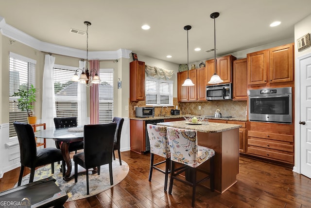 4581 Sagebrush Ct, Snellville, GA 30039 - kitchen with stainless steel appliances, a chandelier, tasteful backsplash, dark wood-style floors, and a kitchen island