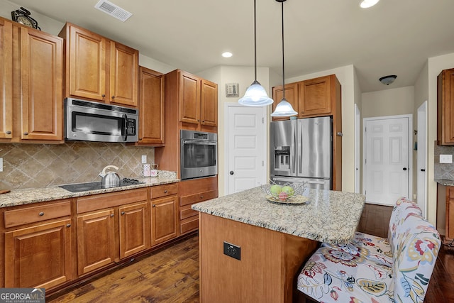 4581 Sagebrush Ct, Snellville, GA 30039 - kitchen with appliances with stainless steel finishes, dark wood finished floors, light stone counters, pendant lighting, and recessed lighting