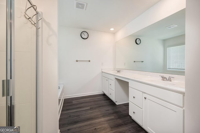 668 Isom Walk, Suwanee, GA 30024 - full bath with double vanity, wood finished floors, baseboards, and recessed lighting