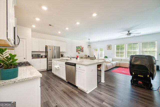 668 Isom Walk, Suwanee, GA 30024 - kitchen with appliances with stainless steel finishes, open floor plan, a sink, dark wood-type flooring, and white cabinetry