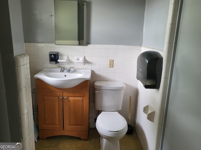 957 Astor Ave, Forest Park, GA 30297 - bathroom featuring toilet, vanity, tile walls, and tile patterned flooring