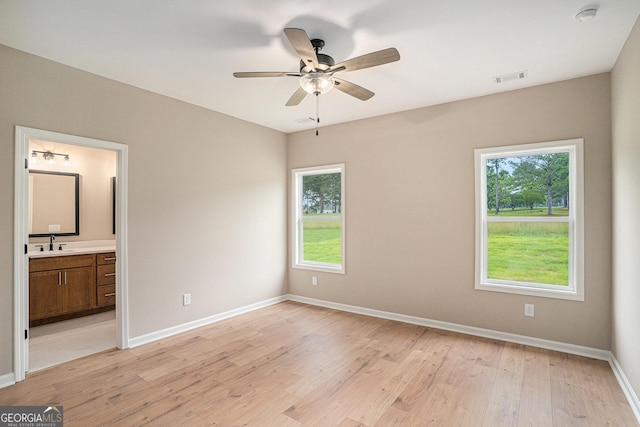 1573 Cabin Creek Trl, Griffin, GA 30223 - unfurnished bedroom with a sink, multiple windows, light wood-style flooring, and baseboards
