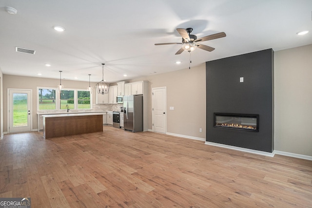 1573 Cabin Creek Trl, Griffin, GA 30223 - kitchen featuring stainless steel appliances, open floor plan, light countertops, a fireplace, and recessed lighting
