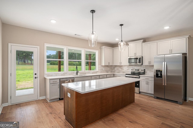 1573 Cabin Creek Trl, Griffin, GA 30223 - kitchen with appliances with stainless steel finishes, a sink, light countertops, decorative backsplash, and light wood-style flooring