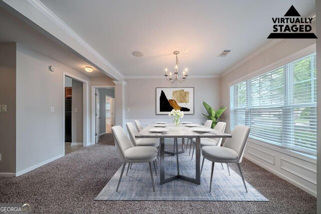 dining room featuring carpet, a chandelier, ornamental molding, a decorative wall, and wainscoting