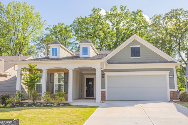 view of front facade featuring driveway, a front yard, brick siding, a garage, and roof with shingles