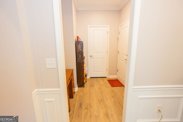 hall featuring light wood-type flooring and crown molding
