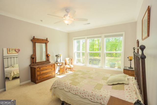 carpeted bedroom featuring baseboards, ornamental molding, and ceiling fan