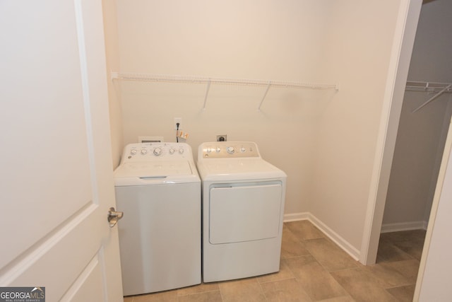 laundry room with washer and clothes dryer and light tile patterned floors