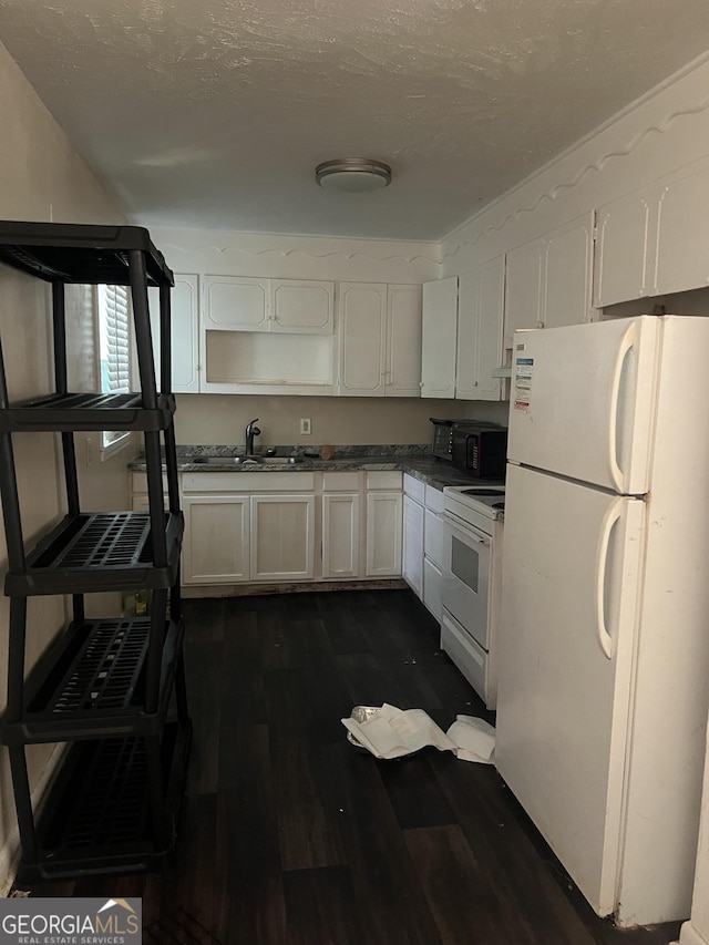 908 Crestwood Ter, Warner Robins, GA 31088 - kitchen featuring white appliances, dark wood finished floors, a sink, dark countertops, and white cabinets