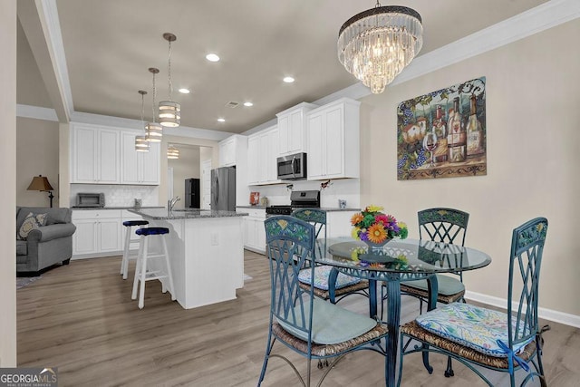 174 Crown Pointe Dr, Dawsonville, GA 30534 - dining space featuring a chandelier, crown molding, recessed lighting, light wood-style floors, and baseboards