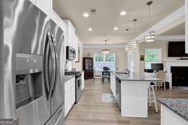 174 Crown Pointe Dr, Dawsonville, GA 30534 - kitchen featuring stainless steel appliances, a sink, white cabinetry, light wood-style floors, and ornamental molding