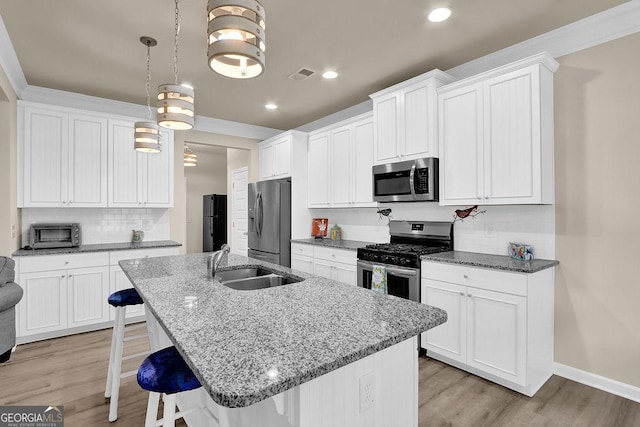 174 Crown Pointe Dr, Dawsonville, GA 30534 - kitchen with stainless steel appliances, a sink, a breakfast bar, tasteful backsplash, and light wood-type flooring