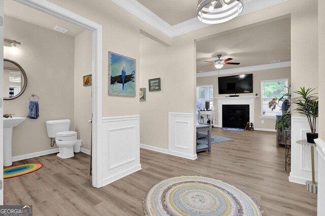 174 Crown Pointe Dr, Dawsonville, GA 30534 - living room featuring crown molding, ceiling fan, light wood-style flooring, a glass covered fireplace, and baseboards