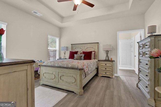 174 Crown Pointe Dr, Dawsonville, GA 30534 - bedroom with a tray ceiling, light wood finished floors, baseboards, ceiling fan, and ensuite bathroom