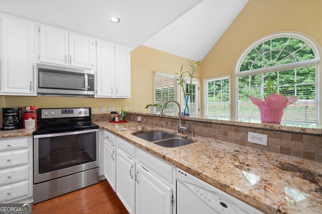 8035 Canter Ln, Alpharetta, GA 30009 - kitchen with appliances with stainless steel finishes, a sink, healthy amount of natural light, lofted ceiling, and light stone countertops