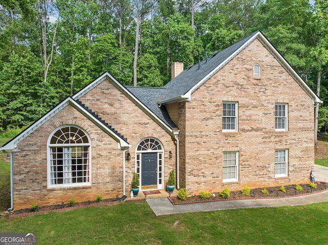 8035 Canter Ln, Alpharetta, GA 30009 - view of front of house featuring a front lawn, a chimney, brick siding, roof with shingles, and view of scattered trees