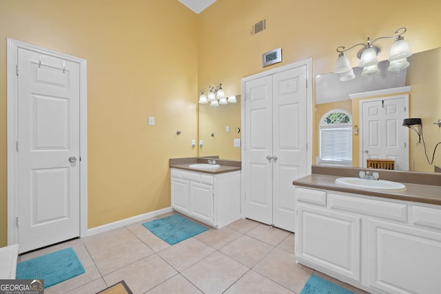 8035 Canter Ln, Alpharetta, GA 30009 - full bathroom with tile patterned flooring, two vanities, a towering ceiling, and baseboards