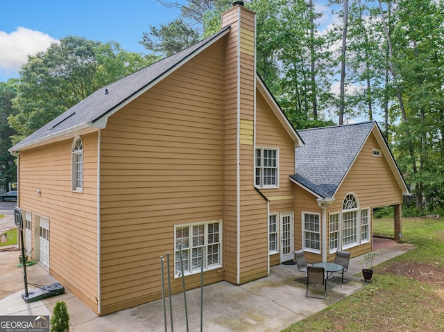 8035 Canter Ln, Alpharetta, GA 30009 - rear view of house with a chimney, a shingled roof, a patio, and an attached garage