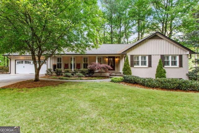 ranch-style house with an attached garage, driveway, a front yard, and board and batten siding