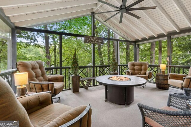 sunroom featuring an outdoor fire pit, a ceiling fan, and healthy amount of natural light
