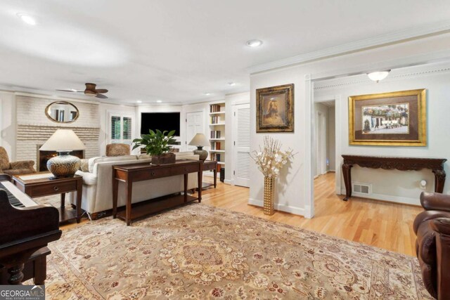 living area with a ceiling fan, ornamental molding, recessed lighting, wood finished floors, and baseboards