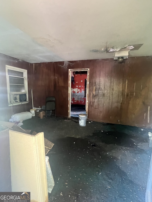 unfurnished living room featuring wood walls, concrete flooring, and cooling unit