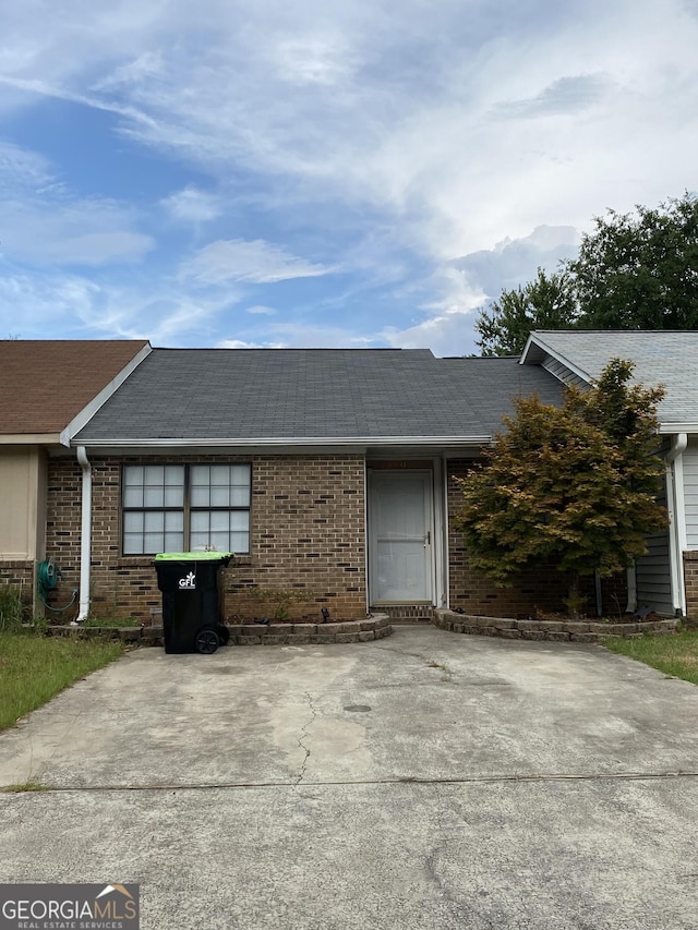 view of front of home with brick siding and a shingled roof