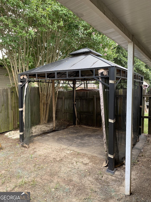 exterior space with fence, a carport, and a gazebo
