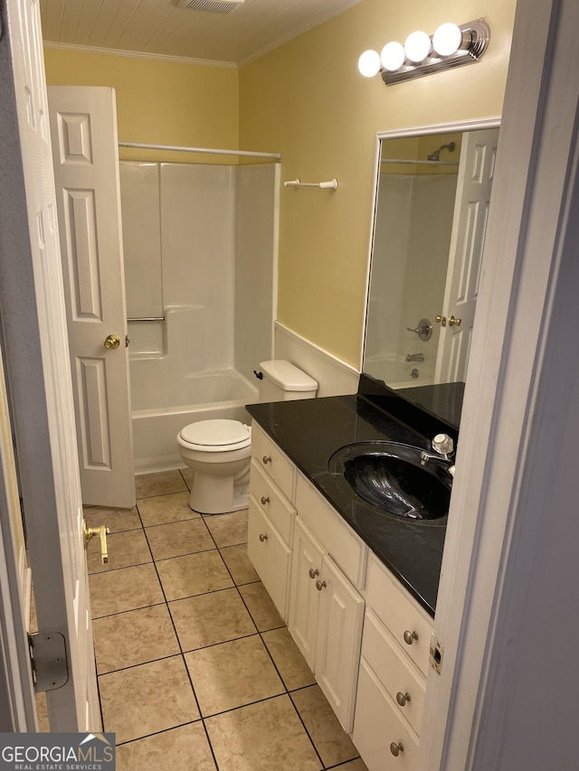 bathroom featuring bathing tub / shower combination, tile patterned flooring, vanity, crown molding, and toilet