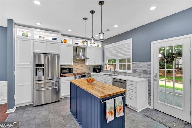 kitchen with stainless steel appliances, butcher block counters, white cabinets, healthy amount of natural light, and recessed lighting