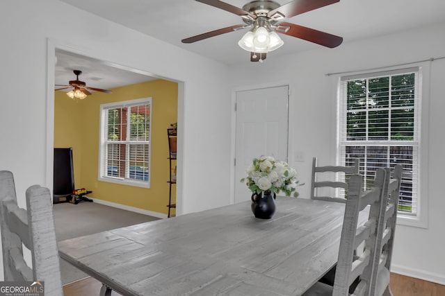 dining space featuring ceiling fan and baseboards