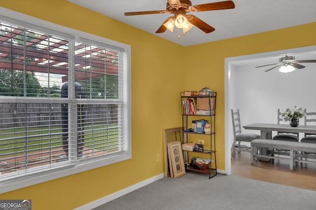 carpeted dining area with ceiling fan and baseboards