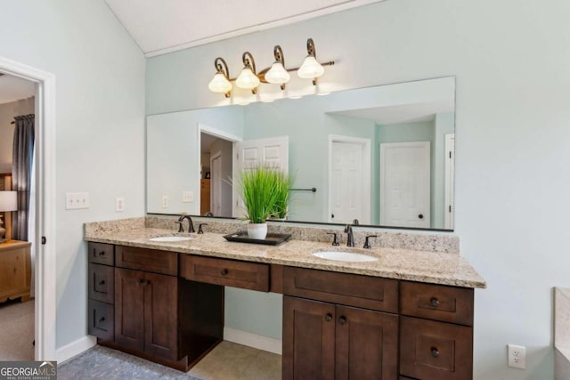 bathroom featuring double vanity and baseboards