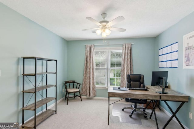 carpeted office with baseboards, ceiling fan, and a textured ceiling