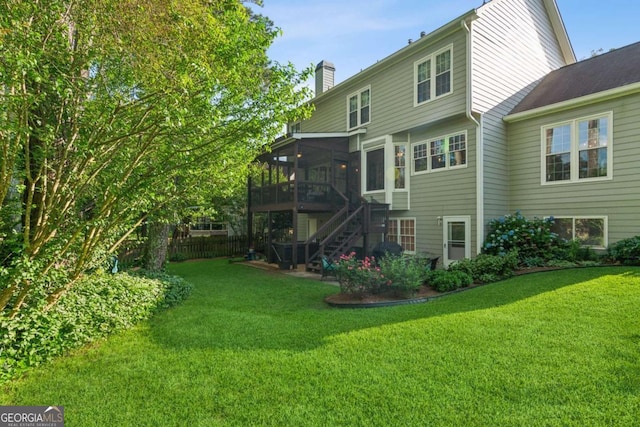 rear view of property featuring a sunroom, stairs, and a chimney