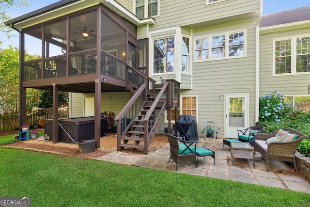 back of house with a hot tub, a sunroom, a patio, and stairway