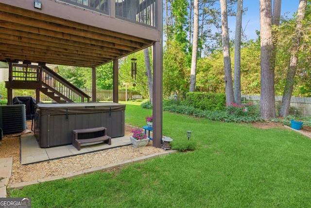 view of yard featuring a hot tub, a patio, stairs, and central AC unit