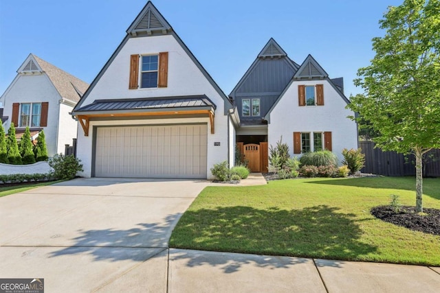 190 Arbor Garden Cir, Newnan, GA 30265 - tudor house featuring a garage, driveway, and a standing seam roof