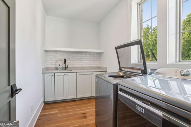190 Arbor Garden Cir, Newnan, GA 30265 - laundry area featuring washer and clothes dryer, cabinet space, and light wood-style flooring
