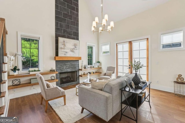 190 Arbor Garden Cir, Newnan, GA 30265 - living area featuring high vaulted ceiling, wood finished floors, healthy amount of natural light, a stone fireplace, and a chandelier