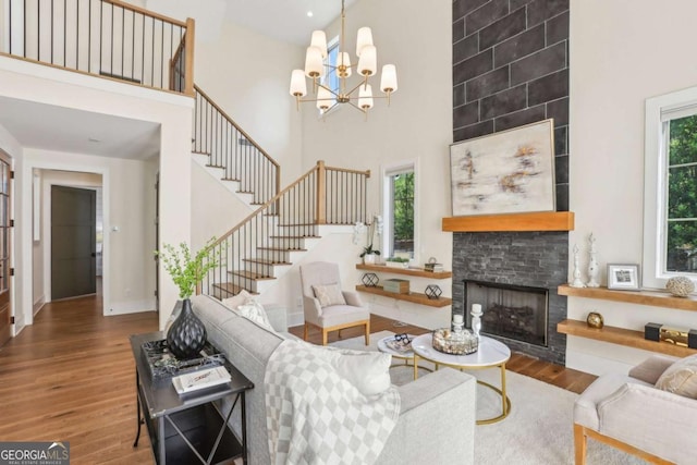 190 Arbor Garden Cir, Newnan, GA 30265 - living area with a high ceiling, wood finished floors, a stone fireplace, stairway, and a chandelier