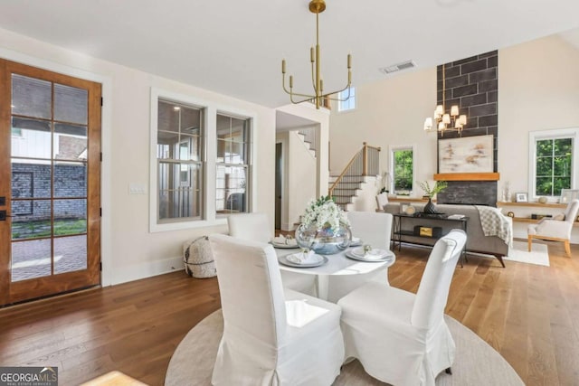 190 Arbor Garden Cir, Newnan, GA 30265 - dining room with a chandelier, stairway, wood finished floors, a high ceiling, and baseboards