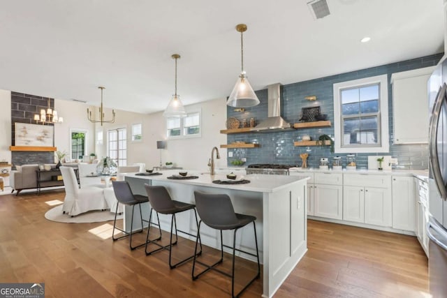 190 Arbor Garden Cir, Newnan, GA 30265 - kitchen featuring wall chimney exhaust hood, white cabinetry, backsplash, and hardwood / wood-style floors