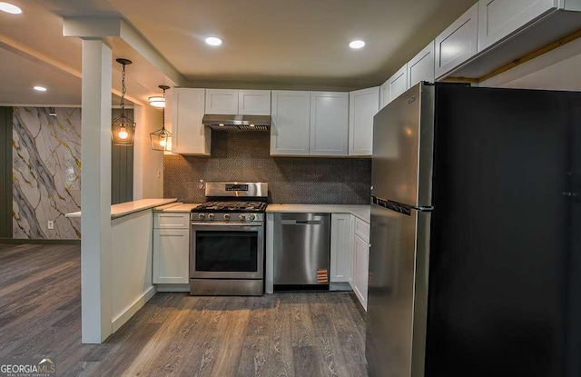 1772 Martin Pl SE, Smyrna, GA 30080 - kitchen with appliances with stainless steel finishes, under cabinet range hood, light countertops, dark wood-type flooring, and recessed lighting