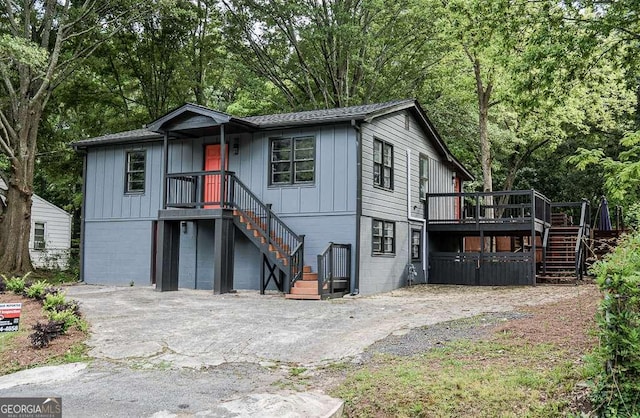 1772 Martin Pl SE, Smyrna, GA 30080 - view of front of house with stairs, a deck, board and batten siding, and view of wooded area