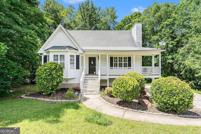 view of front of property with a porch, a chimney, a front yard, and stairs