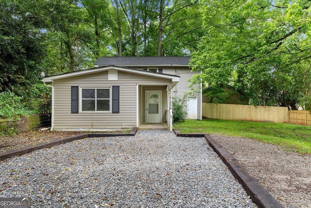 view of front facade featuring fence and gravel driveway